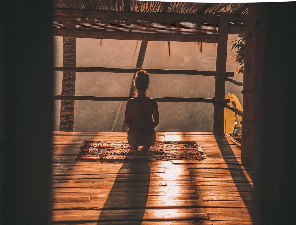 Woman meditating in a tropical landscape in sunlight