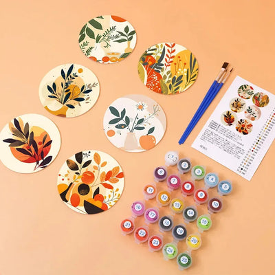 Plant-themed coasters, paints, brushes, and a color card on the table.