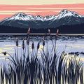 Thumbnail for The picture shows a lake landscape with grasses lining the water. In the background, mountains and the warm hues of the sunset can be seen.