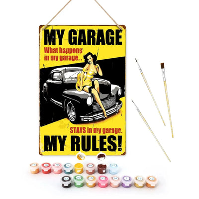 Pre-painted My Garage paint-by-numbers set, featuring a retro-style metal sign, acrylic paint pots, and three brushes on display.