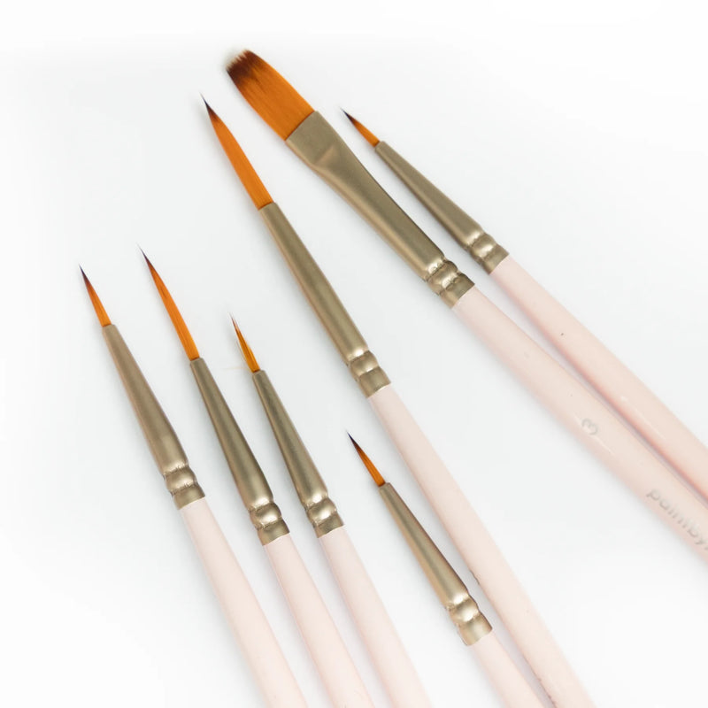 Close-up of fine brush tips and a wide flat brush in the SINOART paint by numbers set