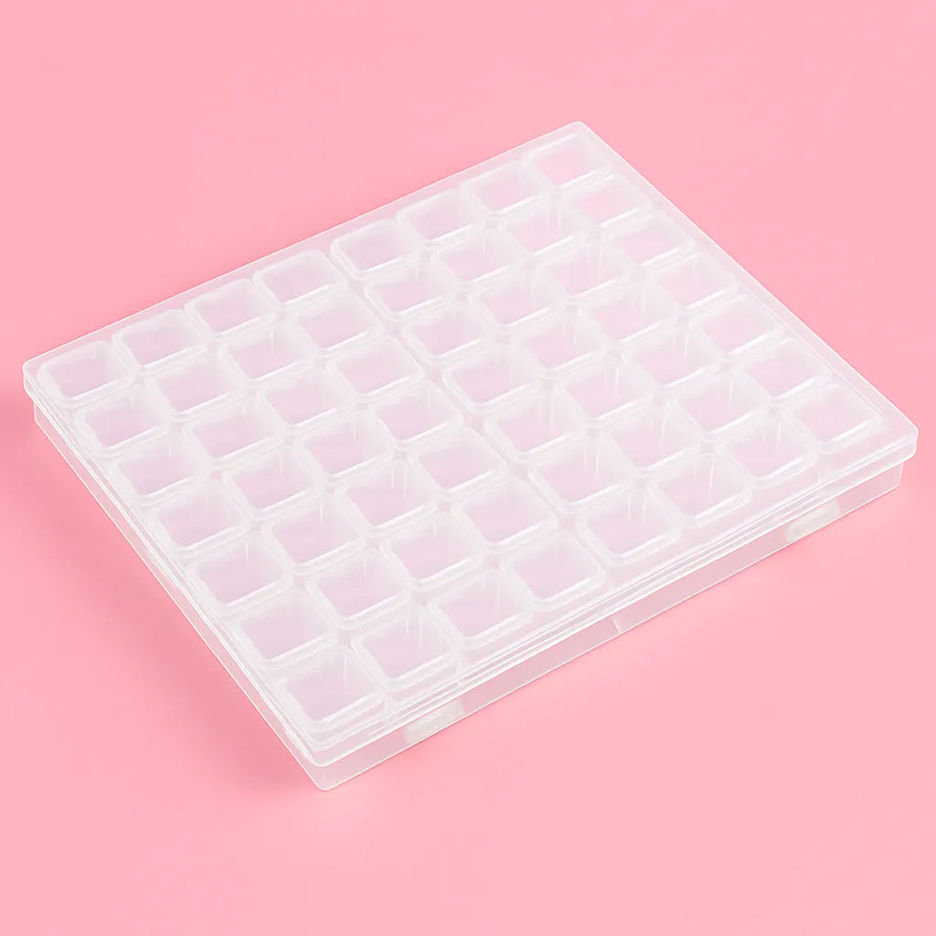 Läpinäkyvä muovinen säilytyslokerikko, jossa on 56 pientä lokeroa timanttimaalauksen tarvikkeille. Laatikko on suljettuna vaaleanpunaisella taustalla.