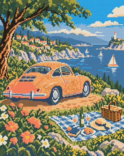 Diamond painting-motiv med en orange veteranbil vid en picknickfilt med havet i bakgrunden