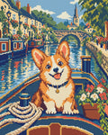 Miniatyrbild: Corgi i kanalbåt framför gamla hus med fönsterblommor, stenbro och kyrktorn