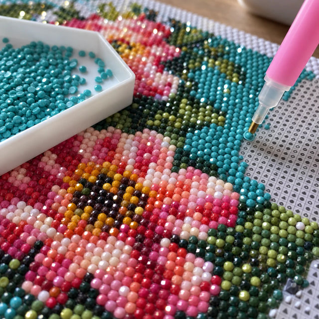 Diamanter i akryl på en diamond painting-duk och en diamantpenna
