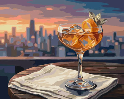 Cocktail-lasi auringonlaskussa numeromaalaus. Etualalla juomalasi, taustalla kaupunkisiluetti.