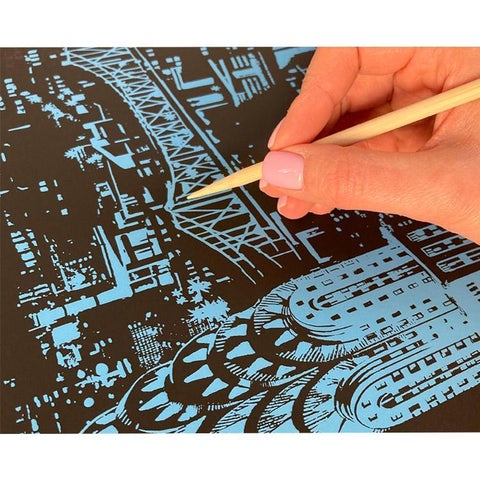 person scratching a scratch image with a wooden pen