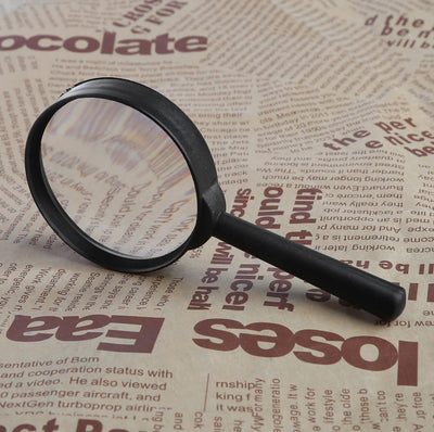 magnifying glass on top of the newspaper