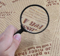 Thumbnail for a person magnifies text in the newspaper with a magnifying glass
