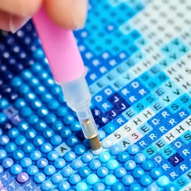 Placing diamond painting drills on the canvas with an applicator pen